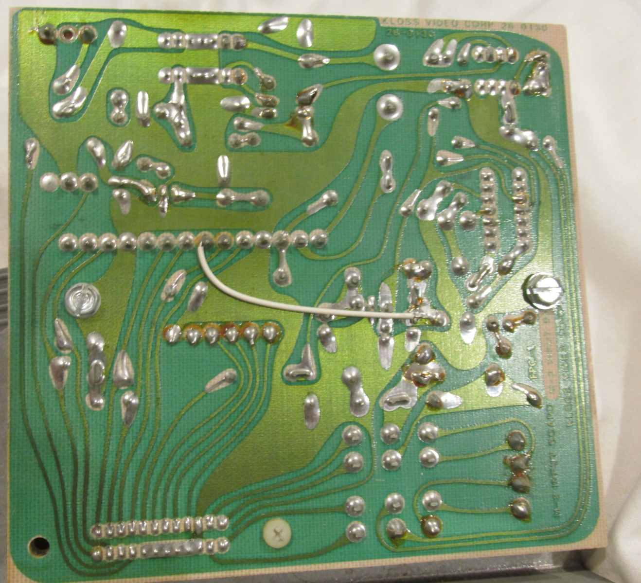 A pink L-shaped circuit board on a pink background