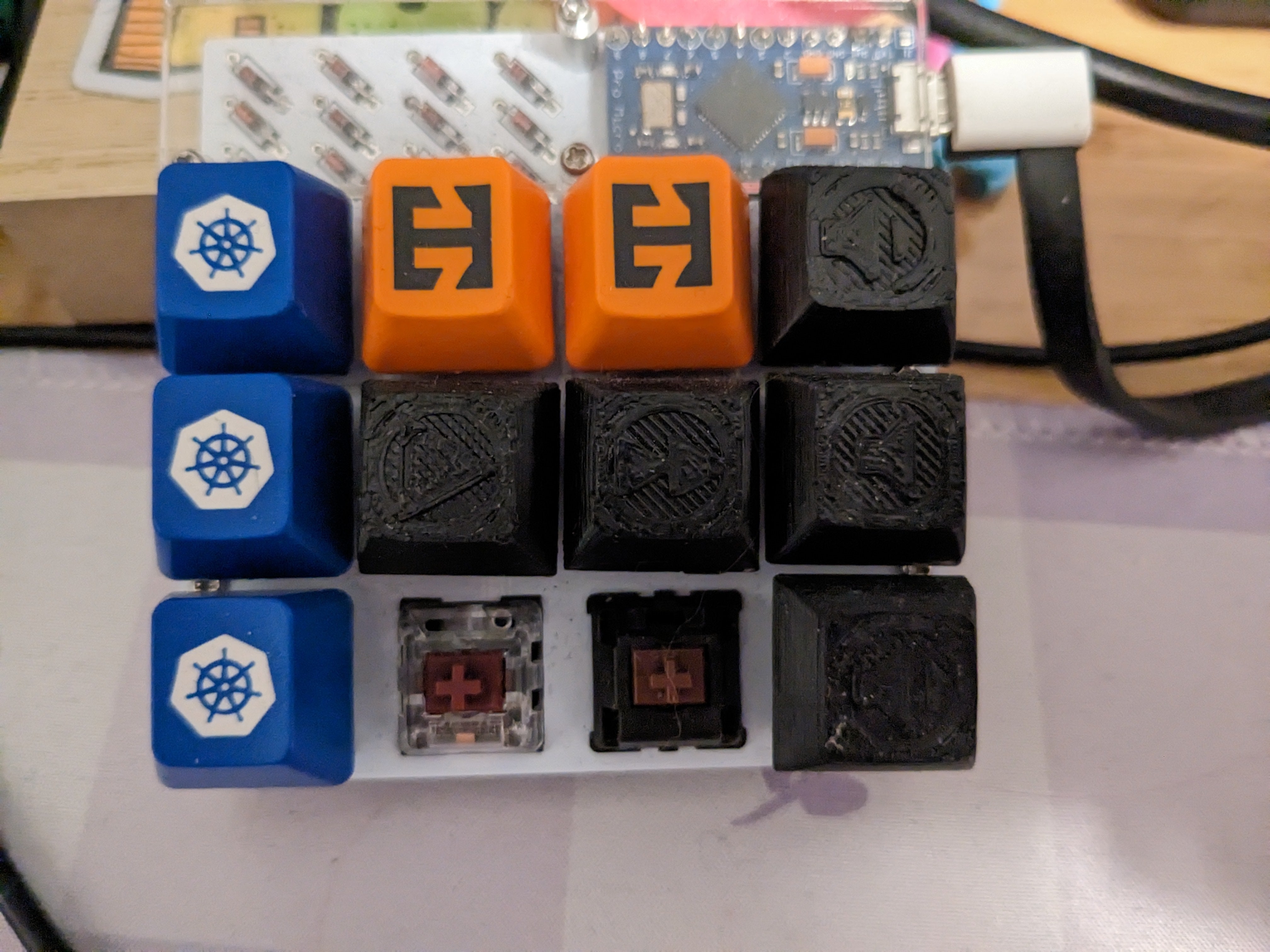 a small 3x4 keyboard. some of the keycaps have 3d-printed symbols like play, skip forward, volume up, and volume down.