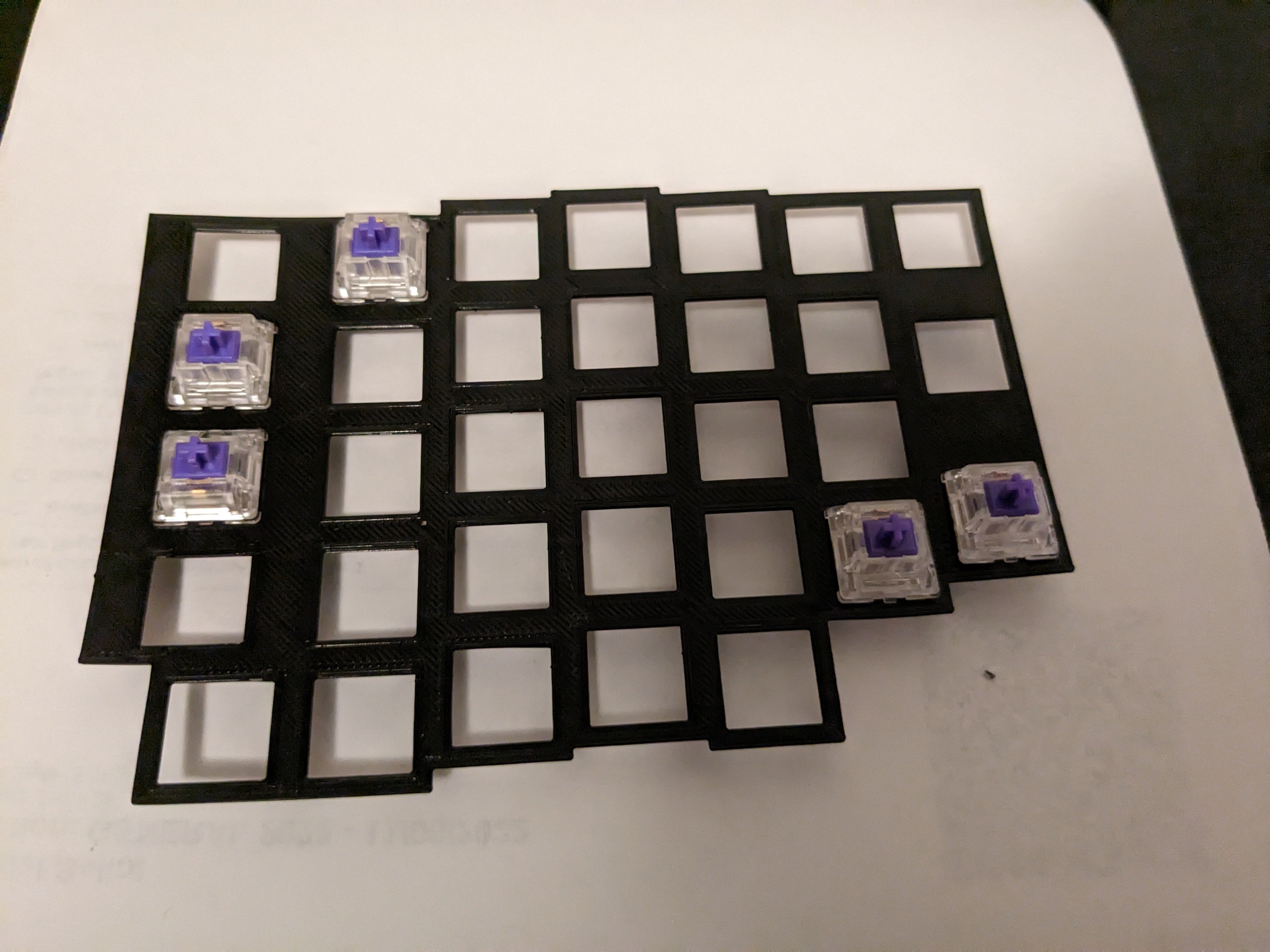 white keycap outlines, a green grid, and black case walls around it
