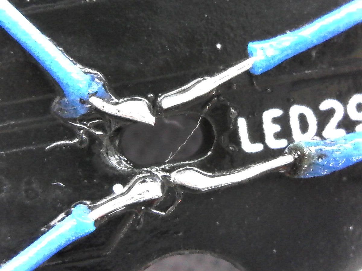 four small blue wires soldered onto pads labellexd LED 29